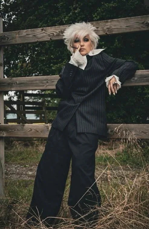 Laurence B. en tailleur noir à l’extérieur